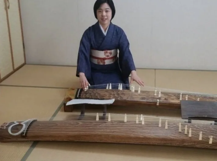 紺色の着物姿でお箏を演奏する講師の様子